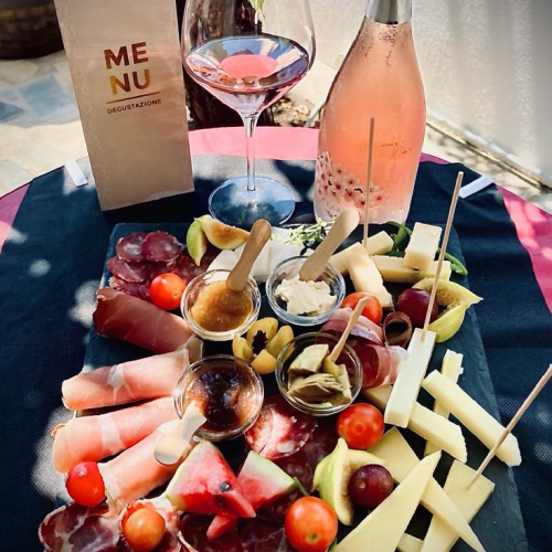 Persone che degustano vini e formaggi in un negozio